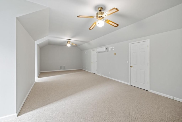 additional living space featuring ceiling fan, vaulted ceiling, light carpet, and a wall mounted AC