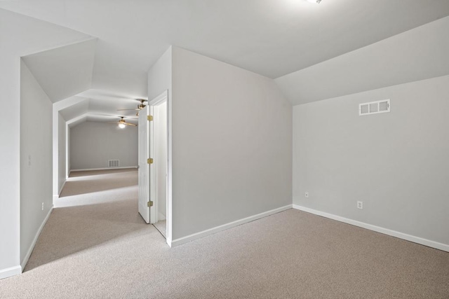 additional living space featuring vaulted ceiling, light colored carpet, and ceiling fan