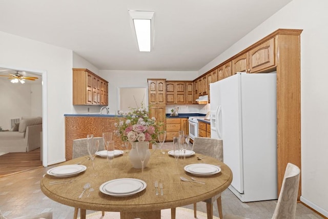 dining space with ceiling fan and light hardwood / wood-style flooring