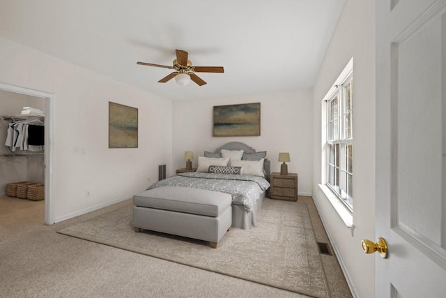 bedroom featuring carpet flooring, a spacious closet, ceiling fan, and a closet