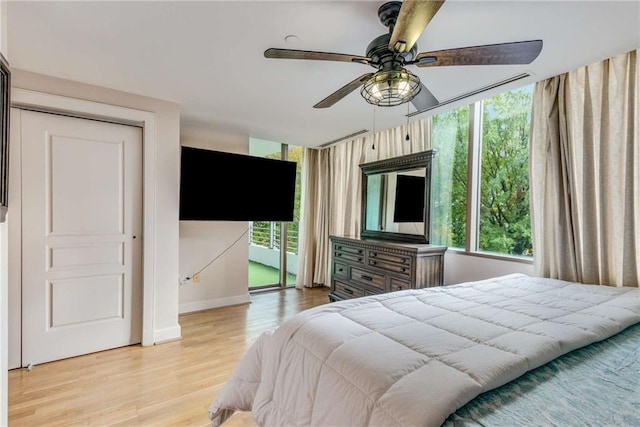 bedroom with ceiling fan, light hardwood / wood-style floors, and access to exterior