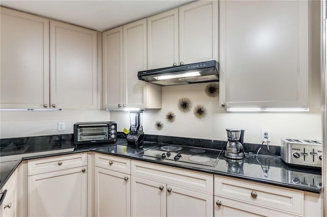 kitchen featuring dark stone countertops and black stovetop