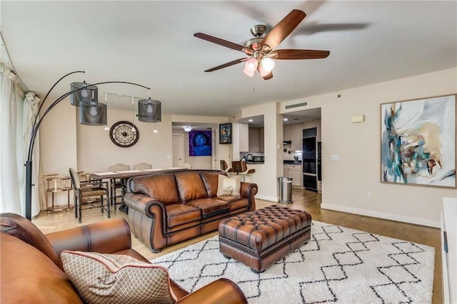 living room with light hardwood / wood-style flooring and ceiling fan