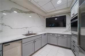 kitchen with gray cabinetry, sink, and stainless steel appliances