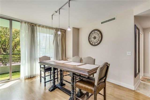 dining area featuring light wood-type flooring and track lighting