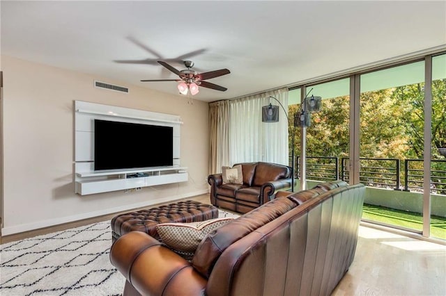 living room with a wealth of natural light, ceiling fan, and light hardwood / wood-style floors