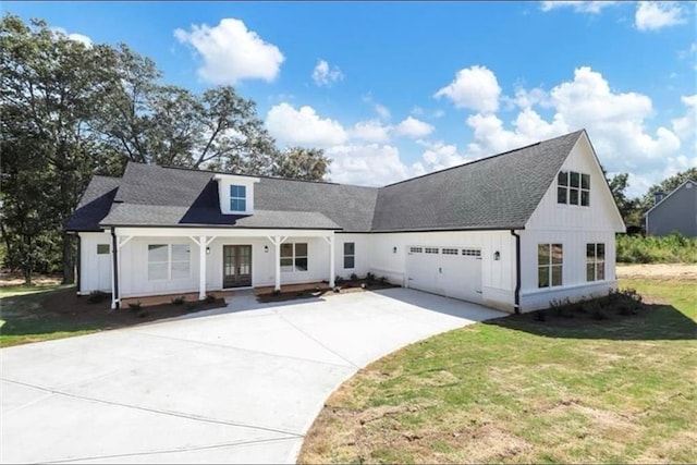 view of front of house with a porch, a garage, and a front lawn