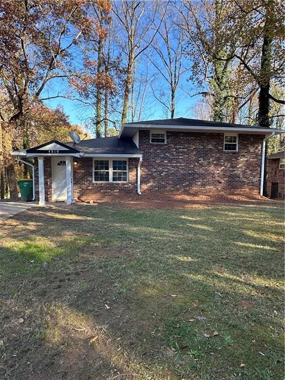 view of front of home with brick siding and a front yard