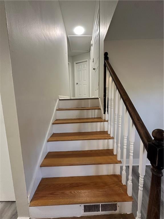 stairs featuring wood finished floors and visible vents