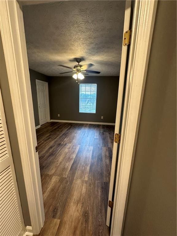5768 Windgate Ln, Lithonia, GA 30058 - unfurnished room featuring dark wood-style flooring, a ceiling fan, and a textured ceiling