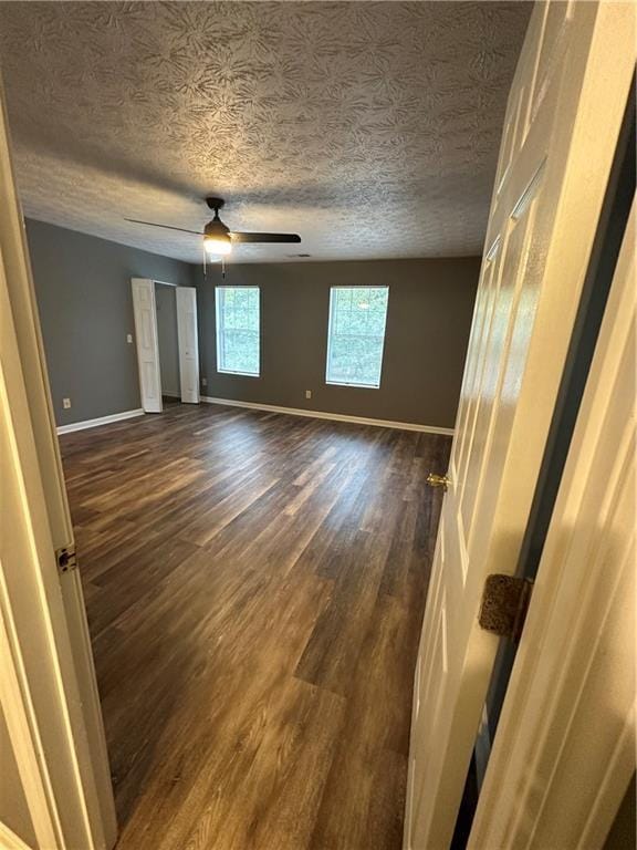 5768 Windgate Ln, Lithonia, GA 30058 - unfurnished bedroom with dark wood-style floors, a textured ceiling, and a ceiling fan