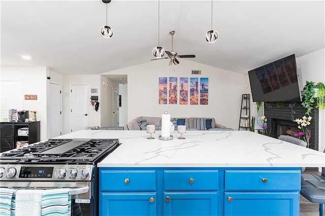 kitchen featuring open floor plan, blue cabinets, vaulted ceiling, a fireplace, and stainless steel range with gas stovetop