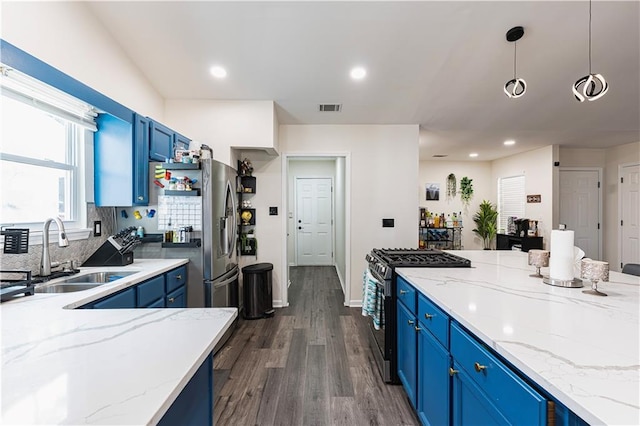 kitchen featuring blue cabinetry, visible vents, appliances with stainless steel finishes, dark wood-type flooring, and a sink