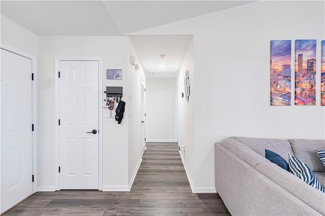 corridor with dark wood finished floors and baseboards