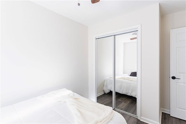 bedroom with a ceiling fan, dark wood finished floors, and a closet