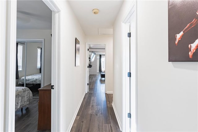 hall with attic access, baseboards, and dark wood finished floors