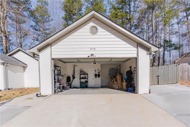 garage with fence and driveway