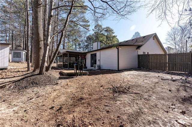 back of property featuring a sunroom, fence, and a chimney