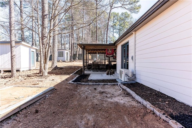 view of yard featuring a patio, ac unit, and an outdoor structure