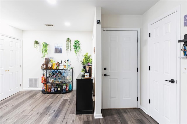 entryway featuring wood finished floors, visible vents, and baseboards