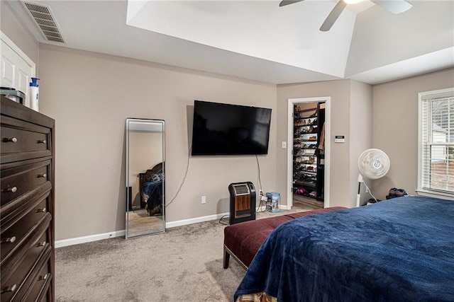 carpeted bedroom featuring a spacious closet, vaulted ceiling, and ceiling fan