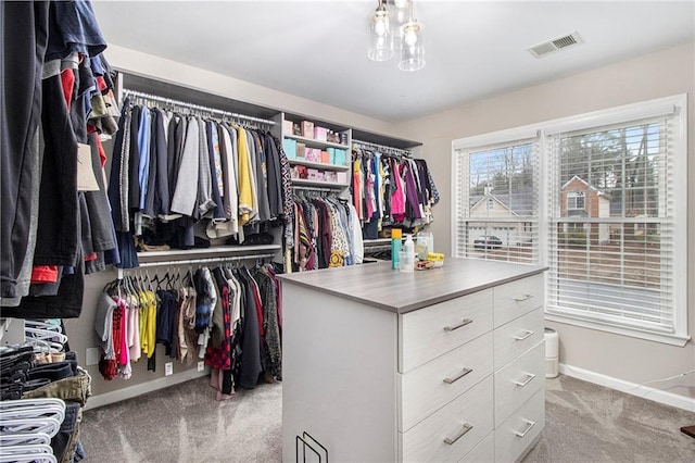 walk in closet featuring light colored carpet