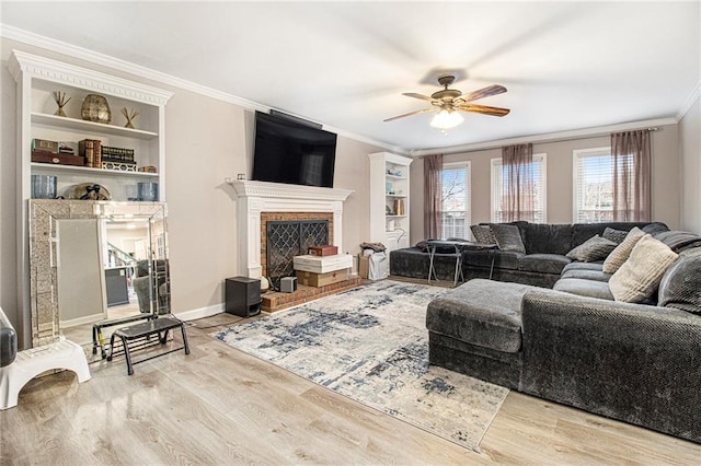 living room with ornamental molding, a brick fireplace, ceiling fan, and light hardwood / wood-style floors