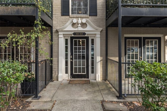 view of exterior entry featuring french doors and brick siding