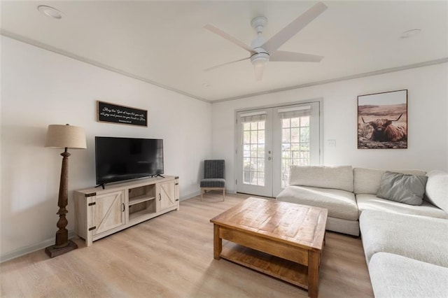 living room with a ceiling fan, french doors, light wood-style floors, crown molding, and baseboards