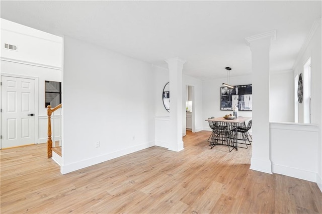 unfurnished room featuring light hardwood / wood-style floors and ornate columns