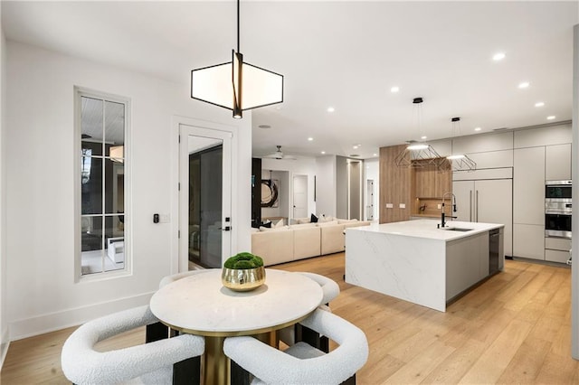 dining area with sink and light wood-type flooring