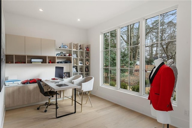 home office with light hardwood / wood-style flooring