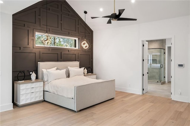 bedroom with vaulted ceiling, connected bathroom, ceiling fan, and light wood-type flooring