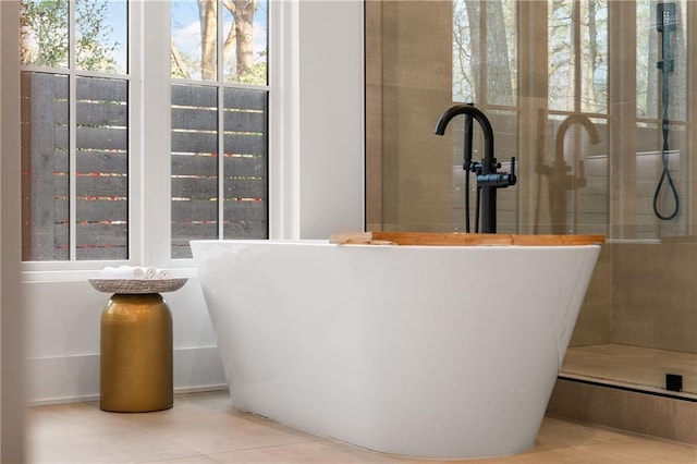 bathroom featuring a washtub, sink, and tile patterned flooring