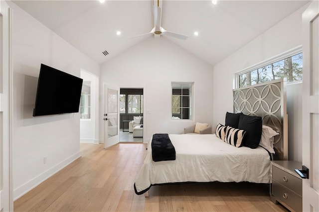 bedroom featuring ceiling fan, high vaulted ceiling, light hardwood / wood-style floors, and multiple windows