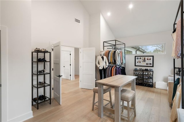 interior space featuring high vaulted ceiling and light hardwood / wood-style floors