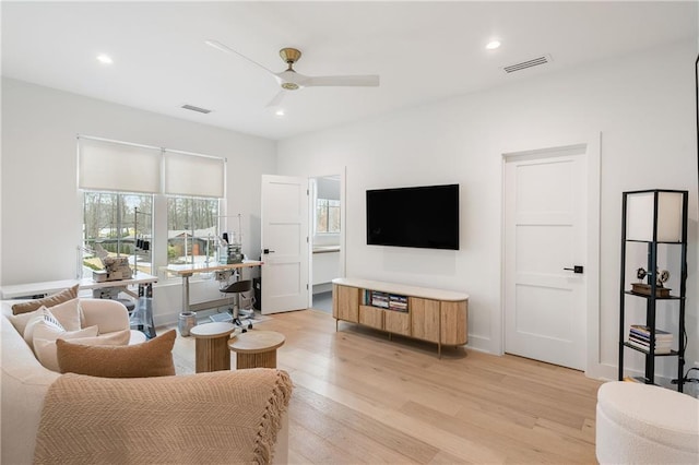 living room with light hardwood / wood-style floors and ceiling fan