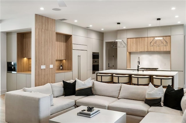 living room featuring sink and light wood-type flooring