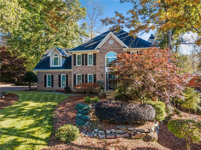 colonial inspired home featuring a front lawn