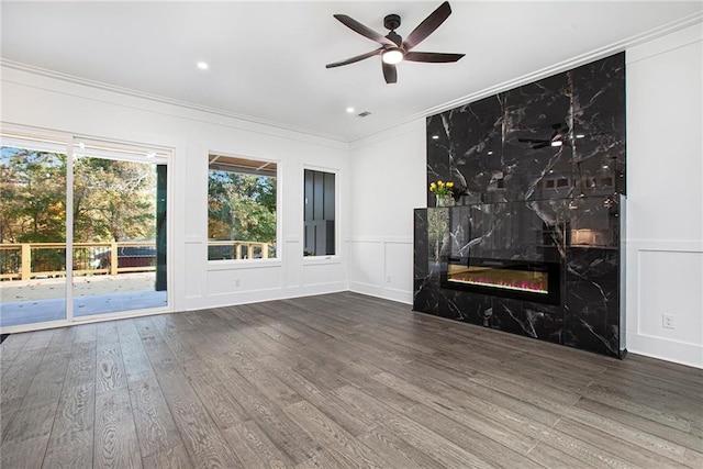 unfurnished living room featuring a premium fireplace, wood-type flooring, and a healthy amount of sunlight