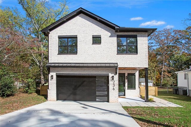 view of front of house with a garage and central AC