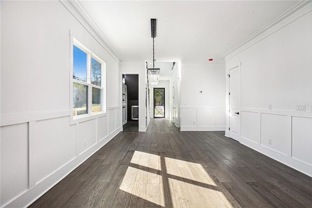 interior space featuring dark wood-type flooring, crown molding, and a notable chandelier