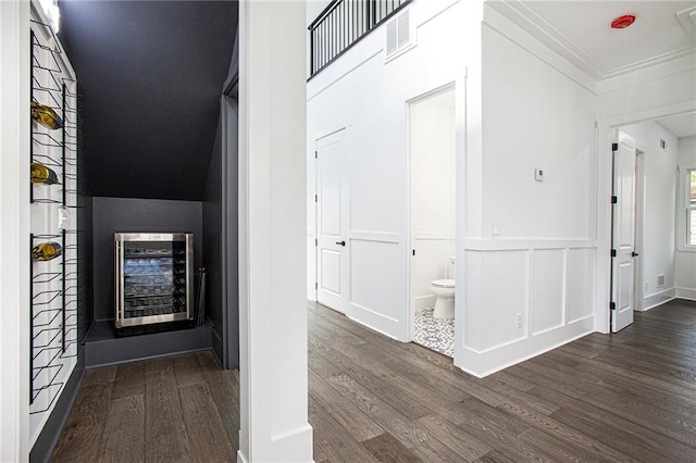 hallway featuring dark hardwood / wood-style flooring, wine cooler, and crown molding