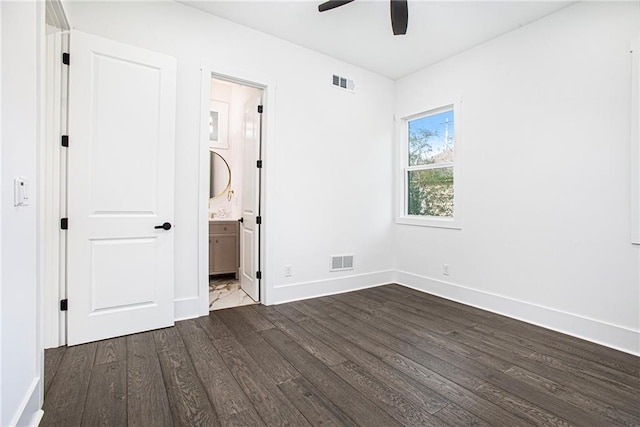 unfurnished bedroom with dark wood-type flooring, ceiling fan, and ensuite bath