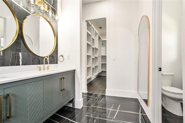 bathroom with hardwood / wood-style flooring, vanity, toilet, and backsplash