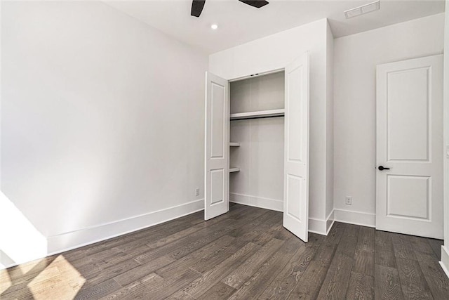 unfurnished bedroom featuring dark wood-type flooring, a closet, and ceiling fan