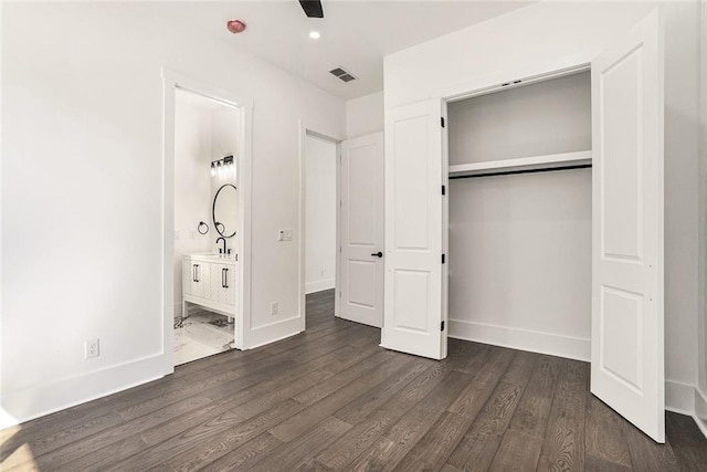 unfurnished bedroom featuring dark hardwood / wood-style flooring, a closet, ceiling fan, and ensuite bathroom