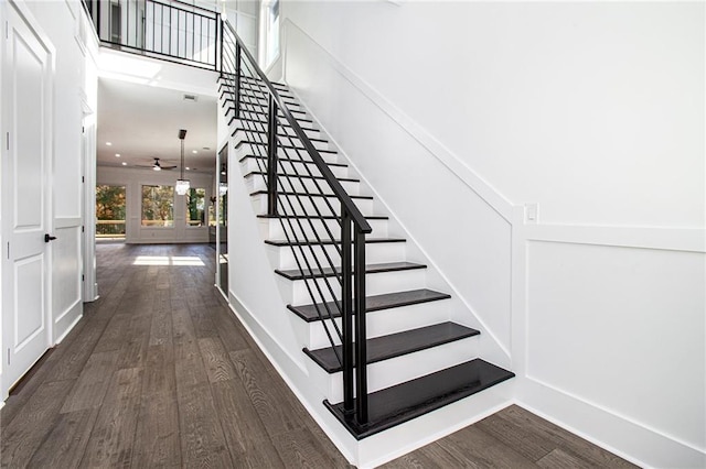 stairs with hardwood / wood-style flooring and ceiling fan