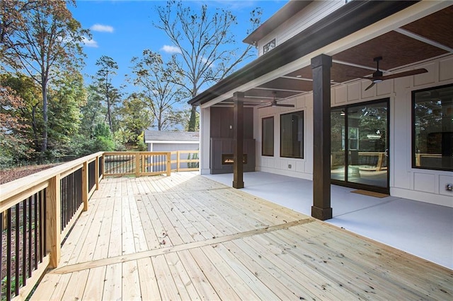 wooden terrace with a patio area and ceiling fan