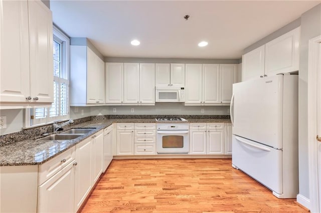 kitchen featuring white cabinetry, sink, and white appliances